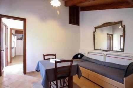 アジェーロラにあるThe Cottageのベッド、テーブル、鏡が備わる客室です。