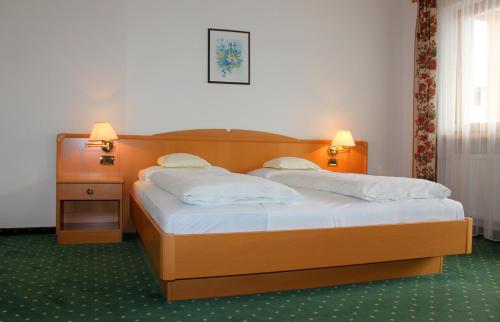 a bedroom with a bed with two pillows on it at Hotel Elisabeth in Chienes