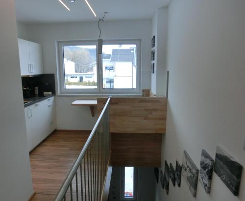 uma escada que leva a uma cozinha com uma janela em Ausblick em Längenfeld