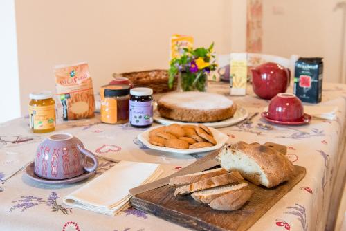 a table with bread and other foods on it at Domus Amica in Lu