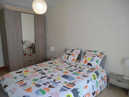 una camera da letto con un letto con un piumone colorato di Le Refuge a Champagné-Saint-Hilaire