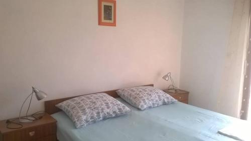 a bedroom with a bed with two pillows on it at Room Rade in Stari Grad