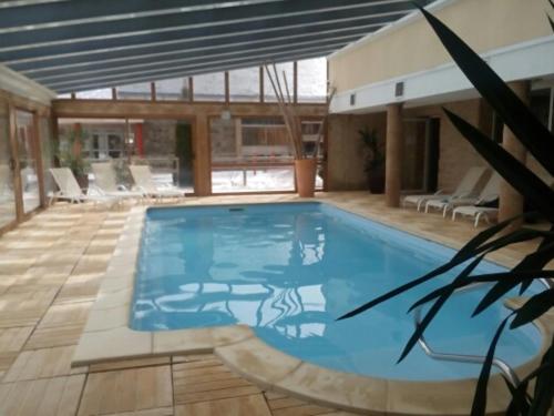 une grande piscine bleue dans un immeuble dans l'établissement CHEZ LYLi & COMPAGNIE, PISCINE, JACCUZZI, SALLE DE SPORT, à Bolquère-Pyrénées 2000