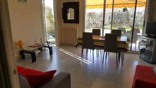 a living room with a dining room table and chairs at Appartement Le Belvédère in Roquebrune-Cap-Martin