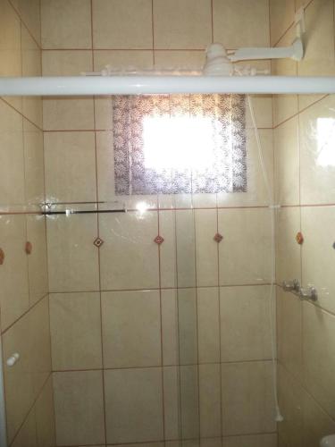 a bathroom with a shower with a window at Chales Recanto das Seriemas in São Roque de Minas