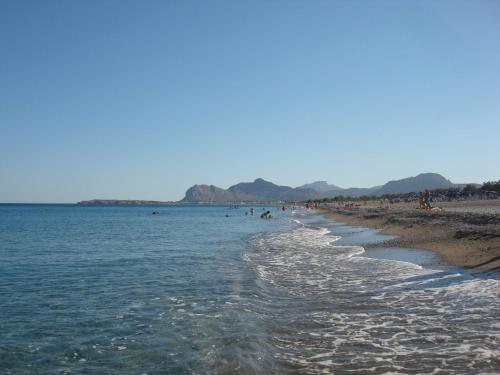 a beach with a group of people swimming in the water at Villa Maroula in Afantou