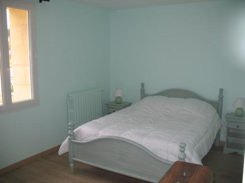 a bedroom with a white bed and a window at Les Gites Du Chardon in Teuillac