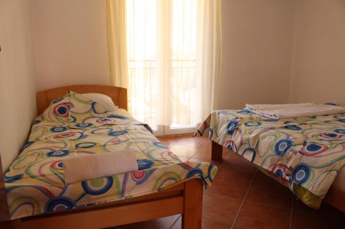 sypialnia z 2 łóżkami pojedynczymi i oknem w obiekcie Apartments Todorovic w Petrovacu na Moru
