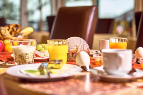 a table with plates of food and drinks on it at Rehwinkel in Bodenmais