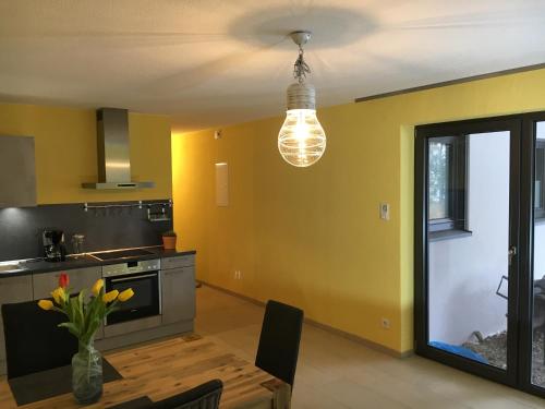 a kitchen with yellow walls and a light fixture at Ferienhaus HAAGALM in Primstal