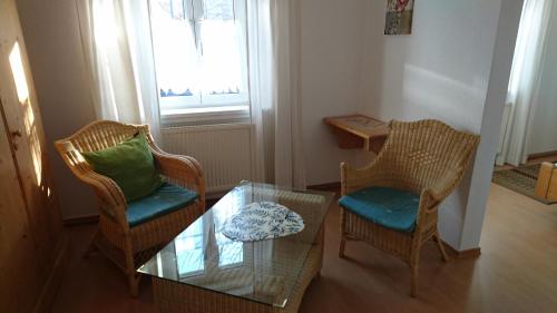 a living room with two chairs and a glass table at Mühldorfer Hof in Altötting