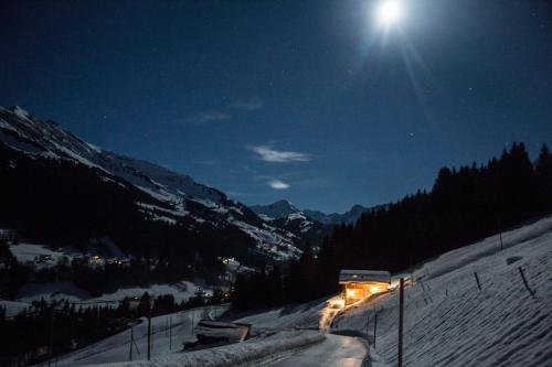 a bus driving down a snow covered slope at night at Boutique Chalet Panoramic Views Hot Tub in Vers L'Eglise