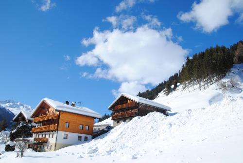a building on a snow covered hill with snow at Ferienwohnungen Böhm in Sankt Jakob in Defereggen