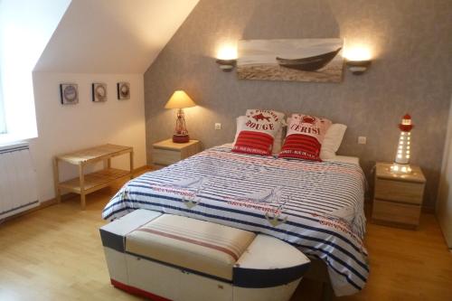 a bedroom with a bed with red pillows on it at Le Trymen in Saint-Guénolé