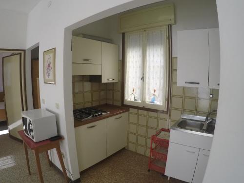 a small kitchen with a sink and a microwave at Casa Francesca - Agenzia Cocal in Caorle