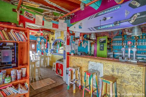 a bar with chairs and a surfboard on the ceiling at One Love Maktub in Paul do Mar