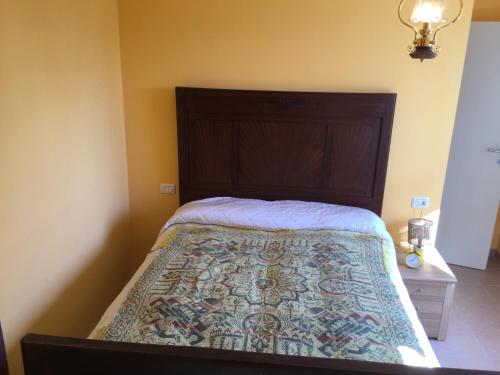 Casa Luisa في بالاتزو: غرفة نوم مع سرير مع اللوح الأمامي الخشبي