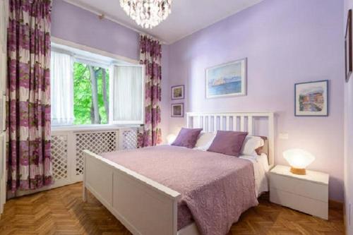 Un dormitorio con una cama con paredes moradas y una lámpara de araña. en Luxury Property in Vatican Area, en Roma