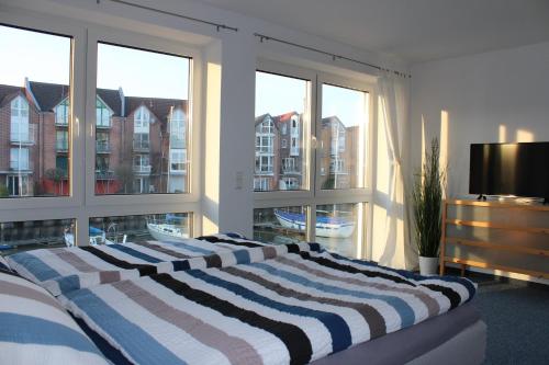 um quarto com uma cama e uma grande janela em Ferienhaus Hafenzeit em Cuxhaven