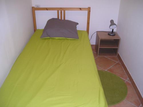 ソリエス・ポンにあるLou Bastidonのナイトスタンド付きの部屋の緑のベッド1台