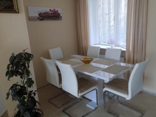 a dining room with a white table and white chairs at Penzion Marjánka in Hluboká nad Vltavou
