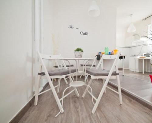 Un comedor blanco con una mesa y sillas. en B&B Lost in Rome, en Roma