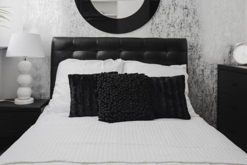 a black and white bedroom with a bed with a black headboard at Grodzka Apartament Centrum in Słupsk