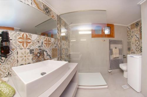 a bathroom with a white sink and a toilet at M house luxury suites in Lixouri