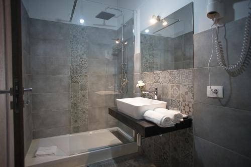 ein Bad mit einem Waschbecken und einer Dusche in der Unterkunft B&B Sorahnia - Design House in Agrigento