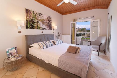 ein Schlafzimmer mit einem Bett und einem Stuhl und einem Balkon in der Unterkunft M house luxury suites in Lixouri