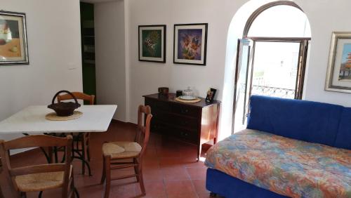 ein Wohnzimmer mit einem blauen Sofa und einem Tisch in der Unterkunft Piccolo Casale in Milazzo