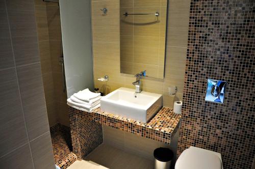 a bathroom with a sink and a toilet and a mirror at Tony's Beach in Vromolithos