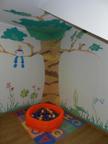 a childs play room with a tree and a bowl of balls at Residence Hotel Raggio Di Luce in Ponte di Legno