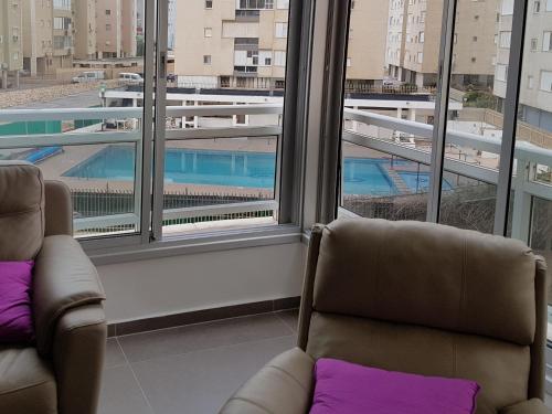 two chairs in a room with a view of a pool at Nitza Boutique Apartment Kosher in Netanya
