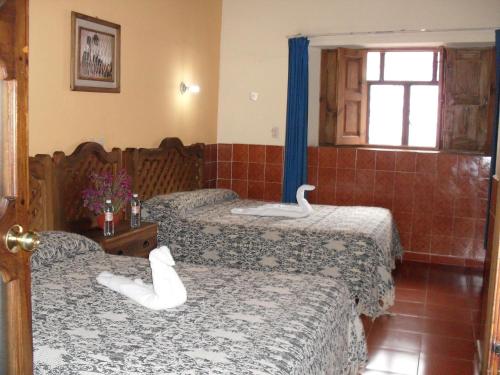 1 dormitorio con 2 camas con zapatos blancos. en Hotel La Casona en San Cristóbal de Las Casas