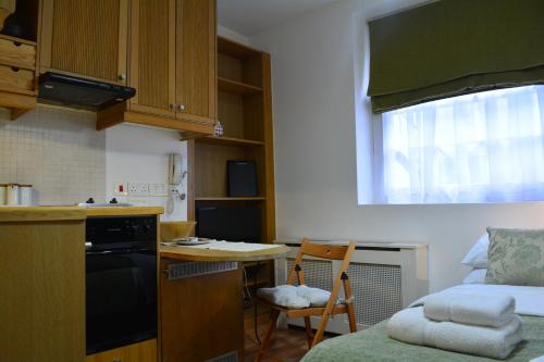 a small kitchen with a small table and a bed at Studios2Let - North Gower in London