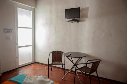 a room with a table and two chairs and a tv at HOTEL LA SELVA Reserva in La Vega