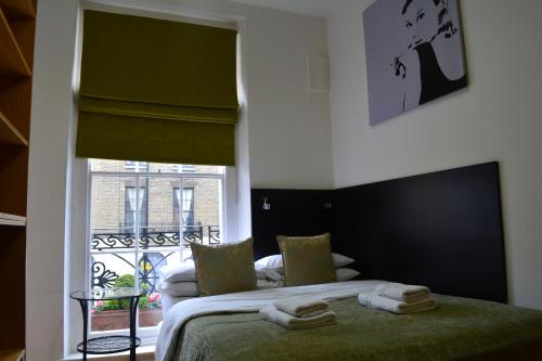 um quarto com uma cama com toalhas em Studios2Let - North Gower em Londres