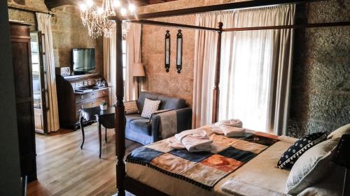 a bedroom with a bed and a chair and a desk at O Retiro do Conde in Villaza