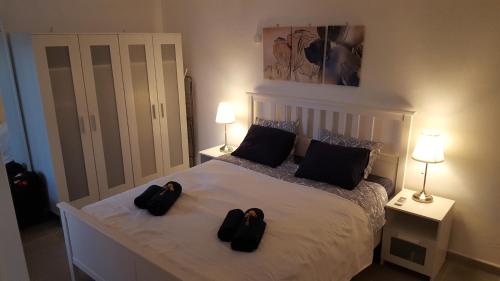 - une chambre avec un lit et 2 chaussons noirs dans l'établissement Bonanza Apartment, à Benalmádena