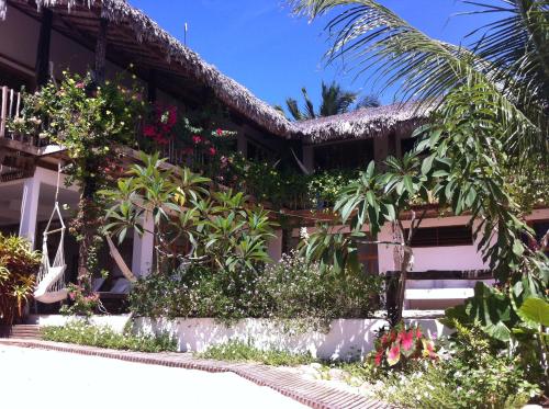 a building with a lot of plants and flowers at Casa da Gwen in Jericoacoara