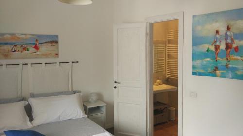 a bedroom with a bed and a painting on the wall at Azzurro B&B in Cefalù
