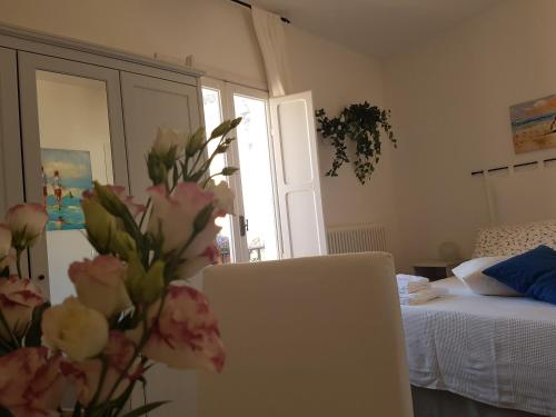 a bedroom with a bed and a laptop and flowers at Azzurro B&B in Cefalù