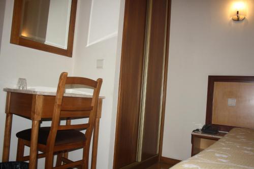 a room with a table and a chair next to a bed at Ze da Rampa Hotel in Aves