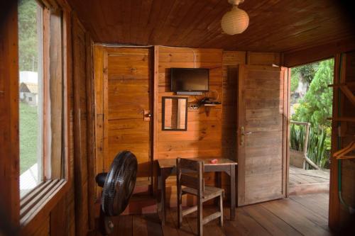 a room with a tv and a chair in a cabin at HOTEL LA SELVA Reserva in La Vega
