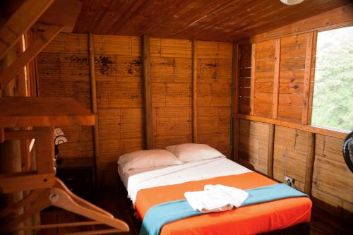 a small room with a bed in a cabin at HOTEL LA SELVA Reserva in La Vega