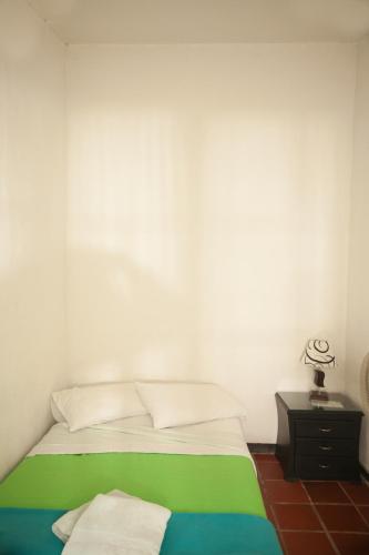 a bedroom with a green and white bed and a nightstand at HOTEL LA SELVA Reserva in La Vega