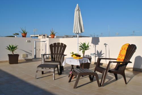 a patio with two chairs and a table on a roof at Casa Frida in San Vito lo Capo