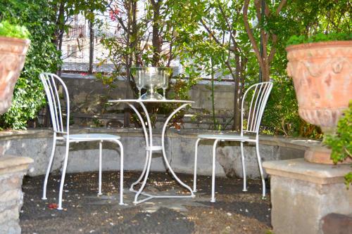 two chairs and a table with a wine glass on it at B&B Villa Maria in Giarre
