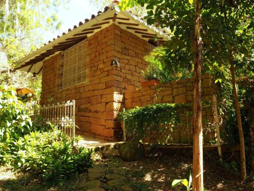 una casa de ladrillo con una valla en un patio en La Cabana de los Novios By Casas del Sur, en Barichara